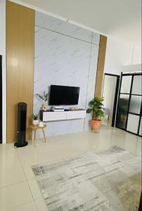 a living room with a flat screen tv on a wall at Spacious House - Ngemplak, Surakarta in Kadipiro