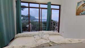 a bedroom with a bed and a large window at Forest Camp El Nido Extension in El Nido