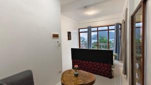 a living room with a table and a tv at Forest Camp El Nido Extension in El Nido +26 photos