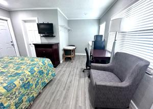 a bedroom with a bed and a desk and a chair at Lemon Bay Motel in Englewood