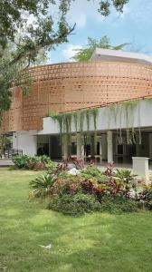 a brick building with a grass yard in front of it at Spacious House - Ngemplak, Surakarta in Kadipiro