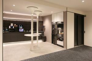 a kitchen with a white table and a refrigerator at CityInn Hotel Taipei Station Branch II in Taipei