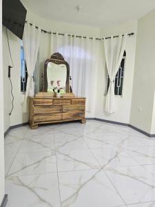 a bathroom with a vanity and a mirror on a tile floor at Palm Breeze Villa in Green Island