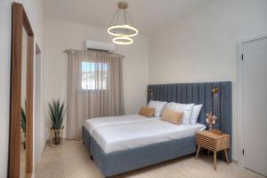 a bedroom with a bed with a blue headboard at Keter HaSimta - כתר הסמטה in Safed