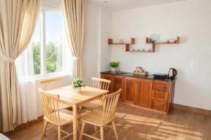 a dining room with a table and chairs and a window at Selima Hotel in Quy Nhon