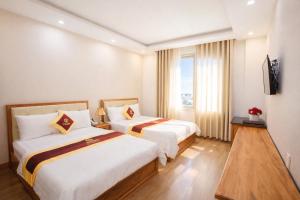 a hotel room with two beds and a window at Selima Hotel in Quy Nhon