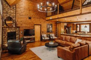 a living room with a couch and a fireplace at Heated Pool, 7 Bedroom Cabin, 6,000 Square Feet, Arcade! in Broken Bow