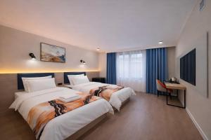 a hotel room with two beds and a desk at Huaxia Hotel Bishkek in Bishkek