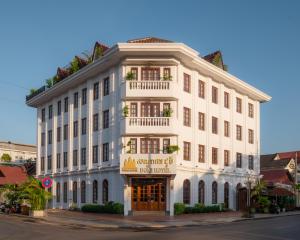 a white building with a sign on the front of it at Domi Hotel in Siem Reap