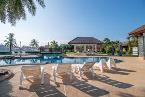 a group of chairs sitting next to a swimming pool at SeaBreeze Residence Mae Phim in Ban Tha Fat