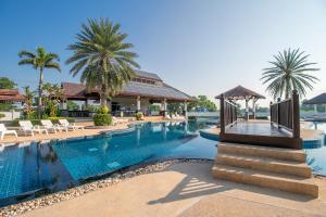 a pool at a resort with chairs and palm trees at SeaBreeze Residence Mae Phim in Ban Tha Fat