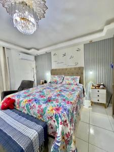 a bedroom with a bed and a chandelier at 4 quartos na Folia de Olinda in Olinda