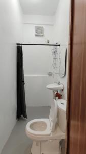 a white bathroom with a toilet and a sink at Forest Camp El Nido Extension in El Nido