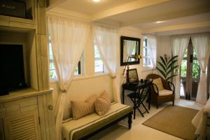 a living room with a couch and a tv and windows at Reserva Monte Sagrado 1 in Utuado