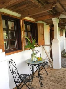 a table and chairs on a porch with a vase of flowers at Reserva Monte Sagrado 1 in Utuado