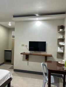 a room with a desk with a tv on a wall at Ashelma resort in Dauis