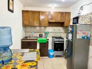 a kitchen with a refrigerator and a table in it at Casa Mama Wela in San Pedro La Laguna