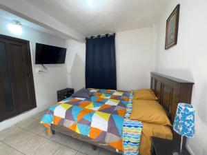 a bedroom with a bed with a colorful quilt at Casa Mama Wela in San Pedro La Laguna