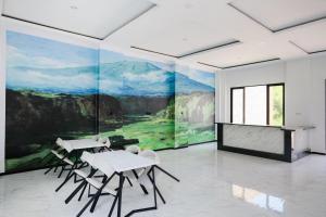 a room with two tables and chairs and a painting at Urbanview Golden Barbie near Jawa Timur Park 2 in Tlekung +55 photos