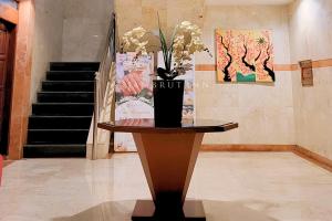 a table with a vase with flowers on top of it at Jambrut Inn in Jakarta
