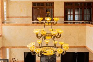 a large yellow chandelier in front of a building at Jambrut Inn in Jakarta +36 photos