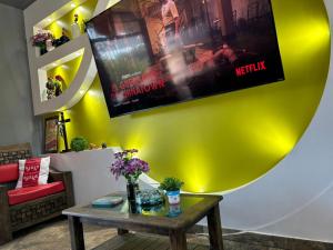a living room with a table and a movie on the wall at Hotel Villa's Camargo in Ixmiquilpan