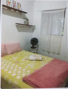 a bedroom with a bed with a blanket and a window at EsPAÇO RUSTIK in Santa Cruz Cabrália
