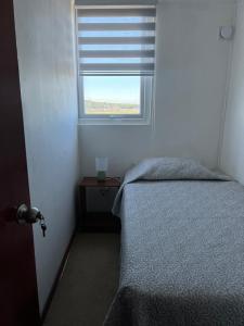 a bedroom with a bed and a window at Vista a los volcanes in Puerto Montt