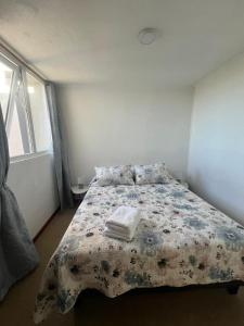 a bedroom with a bed with a floral comforter at Vista a los volcanes in Puerto Montt
