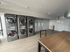 a laundry room with four washing machines and a wooden table at Aparta Suite Centro Internacional Edificio 33DC Piso 29 Estación Trasmilenio Calle 34 in Bogotá