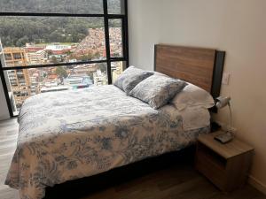a bedroom with a bed and a large window at Aparta Suite Centro Internacional Edificio 33DC Piso 29 Estación Trasmilenio Calle 34 in Bogotá +18 photos