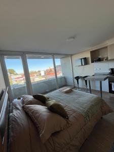 a bedroom with a large bed with a large window at Genesis in Chillán