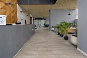 an office lobby with a long hallway with potted plants at Aparta Suite Centro Internacional Edificio 33DC Piso 29 Estación Trasmilenio Calle 34 in Bogotá