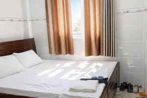 a bed in a room with a window at Phước Hưng 1 Hotel in Vĩnh Long