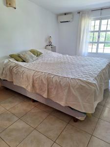a large bed in a room with a large window at La Popelina in Valle Hermoso