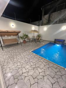 a swimming pool in a room with a table and a bed at Alma del Mar in Volcán Chimborazo