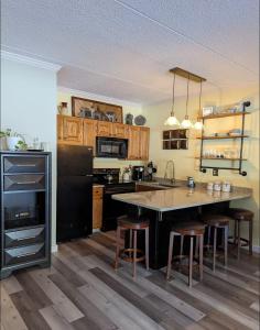 a kitchen with a large kitchen island with bar stools at Cozy condo at Attitash Mountain Village in Bartlett