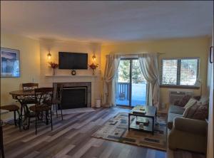 a living room with a couch and a table at Cozy condo at Attitash Mountain Village in Bartlett