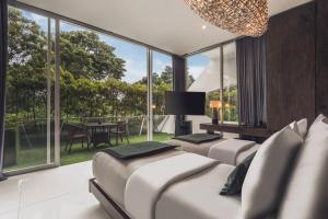 a bedroom with three beds and a large window at Monolocale Resort & Spa Seminyak by Ini Vie Hospitality in Seminyak