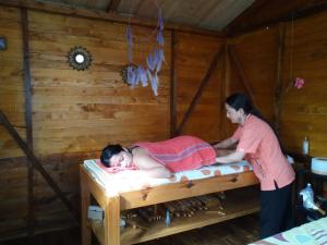 a woman is putting a child on a bed at Cabañas Sumak Kawsay in Colón