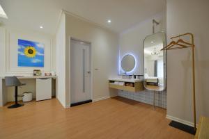 a bathroom with a mirror and a sink and a desk at Station B&B in Tainan