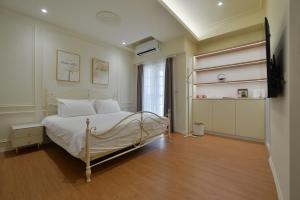 a bedroom with a bed with white sheets and a window at Station B&B in Tainan +43 photos