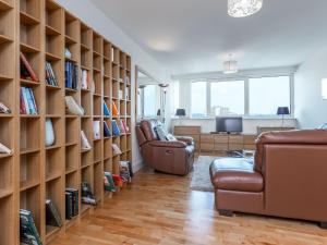 a living room with two chairs and bookshelves at Peregrine in Poole