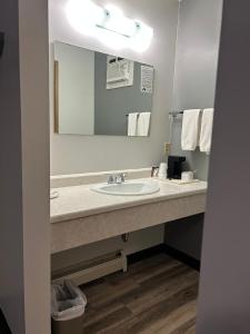 a bathroom with a sink and a mirror at Rimbey Motor Inn in Rimbey +9 photos