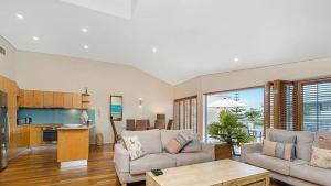 a living room with a couch and a table at Pipi's On The Beach 1 - 2 Fletcher Street in Byron Bay