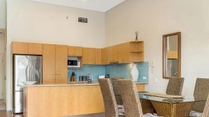 a kitchen with a table and chairs in a room at Pipi's On The Beach 1 - 2 Fletcher Street in Byron Bay +1 photo