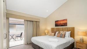 a bedroom with a large bed and a balcony at Pipi's On The Beach 1 - 2 Fletcher Street in Byron Bay