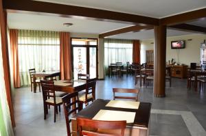 a dining room with wooden tables and chairs at Pensiunea Flora in Cicir