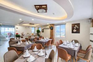 a restaurant with tables and chairs and a clock on the ceiling at Xavia Hotel Quy Nhơn in Quy Nhon