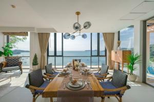 a dining room with a table and chairs and the ocean at Bandara Pool Villas, Phuket in Panwa Beach